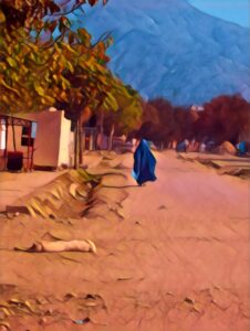Woman in a burqa with a dog lying in the street in Afghanistan.